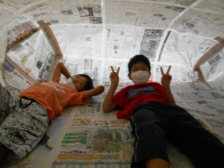 新聞紙ドーム内で寝転んでいる写真