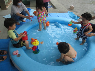 プールの隅に座って水あそび