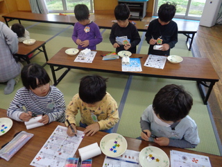 トイレットペーパーの芯で双眼鏡を作っている子どもたち