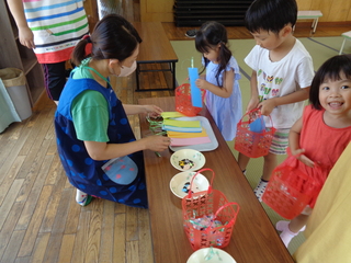 制作に必要な材料を選んでかごに入れている子どもたちの姿