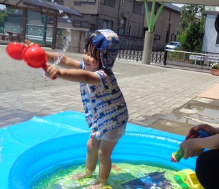 シャベルで水をすくって嬉しそうな表情の男の子