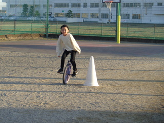 庭に作られたコースを一輪車ではしる2年生