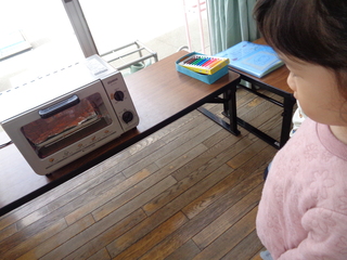 焼き上がる様子を見る子ども