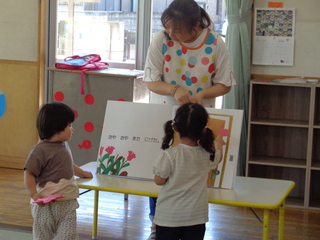 子どもたちが大型絵本をみているところ