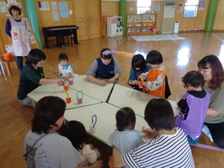 親子さんたちがキャンディを入れるバックを作っているところ