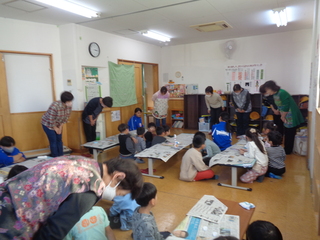 婦人会の方々と子どもたちが一緒にしおり作りをしているところ