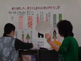 婦人会の人たちがしおり作りの説明をしているところ