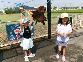 水鉄砲を両手に二刀流で的あてをして喜んでいる様子