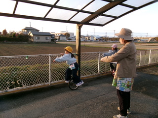 一輪車検定7級　両手でフェンスにつかまってこいているところ