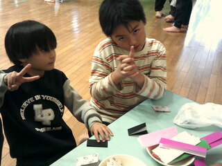 男児たちが折り紙をしているところ