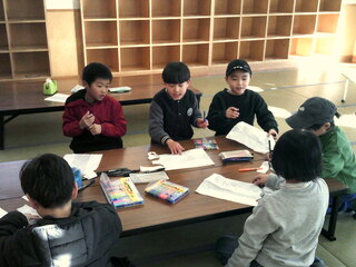 子どもたちが凧あげの凧を作っているところ