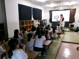 映画上映中のおやくそくを聞く子ども達